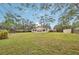 House backyard view with green grass and large trees at 5915 29Th Avenue E Dr, Bradenton, FL 34208