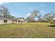 Backyard view showing house, large lawn, and wooden fence at 5915 29Th Avenue E Dr, Bradenton, FL 34208