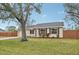 Tan house with blue shutters, large tree, and driveway at 5915 29Th Avenue E Dr, Bradenton, FL 34208