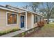 House front view, tan siding, blue door, landscaping at 5915 29Th Avenue E Dr, Bradenton, FL 34208