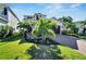 Two-story house with a landscaped front yard, paver driveway, and palm trees at 6137 Voyagers Pl, Apollo Beach, FL 33572