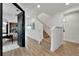 Hallway with light wood floors, white walls, and a staircase leading upstairs at 6137 Voyagers Pl, Apollo Beach, FL 33572