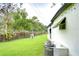 Side view of a white single-story house with AC unit at 6141 Ridgewood Dr, Zephyrhills, FL 33542