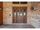 Brown front door with glass panes, set within a brick wall at 6151 Silver Oaks Dr, Zephyrhills, FL 33542