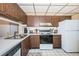 Galley kitchen with wood cabinets and appliances at 6218 Palma Del Mar S Blvd # 208, St Petersburg, FL 33715