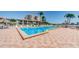 Community pool and patio area with palm trees at 6218 Palma Del Mar S Blvd # 208, St Petersburg, FL 33715