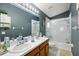 Bathroom with double vanity, shower/tub combo and grey walls at 6325 Chapel Pines Blvd, Wesley Chapel, FL 33545