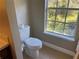 Small bathroom with toilet and window for natural light at 8313 Shallow Creek Ct, New Port Richey, FL 34653