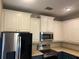 Upper kitchen cabinets, microwave and stainless steel appliances at 8313 Shallow Creek Ct, New Port Richey, FL 34653