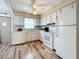 White kitchen cabinets, laminate flooring, and a view into adjacent living area at 8330 Vendome N Blvd, Pinellas Park, FL 33781