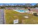 Community pool with surrounding patio furniture and grassy area at 8330 Vendome N Blvd, Pinellas Park, FL 33781