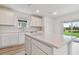 Modern kitchen with white island, quartz countertops and view of backyard at 9801 Crescent Moon Dr, Riverview, FL 33578