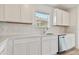 White cabinets, quartz countertops, stainless steel dishwasher and hexagon backsplash at 9801 Crescent Moon Dr, Riverview, FL 33578