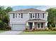 Two-story house with gray siding, stone accents, and a two-car garage at 10826 Patoka Ter, Parrish, FL 34219