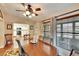 Bright dining room featuring a wooden table set, ceiling fan, and large windows with natural light and views into the kitchen at 13108 Dobree Pl, Riverview, FL 33579