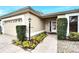 Inviting home entrance with a well-manicured garden, a brick path and a charming exterior light post at 13108 Dobree Pl, Riverview, FL 33579