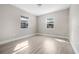 Bright bedroom with two windows, light grey walls, and wood-look flooring at 1349 Woodbine St, Clearwater, FL 33755