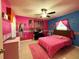 Charming bedroom with pink walls, a bed, and decorative accents at 1447 Coble Rd, Spring Hill, FL 34608