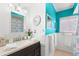 Charming bathroom with teal walls and updated vanity at 1685 Cambridge Dr, Clearwater, FL 33756