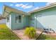 Home exterior showing a light teal house with a small patio at 1685 Cambridge Dr, Clearwater, FL 33756