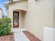 Red front door with glass panels and walkway leading to the entrance at 17608 Glenapp Dr, Land O Lakes, FL 34638