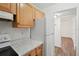 Kitchen with light wood cabinets, white appliances, and marble countertops at 1799 N Highland Ave # 136, Clearwater, FL 33755