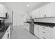 Modern kitchen with white cabinets, black countertops, and stainless steel appliances at 18292 Robinson Ave, Port Charlotte, FL 33948