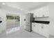 Modern kitchen with white cabinets, black countertops, and stainless steel appliances at 18292 Robinson Ave, Port Charlotte, FL 33948