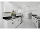 Modern kitchen with white cabinets, black countertops, and stainless steel appliances at 18292 Robinson Ave, Port Charlotte, FL 33948