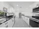 Modern kitchen with white cabinets, black countertops, and stainless steel appliances at 18292 Robinson Ave, Port Charlotte, FL 33948