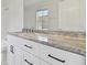 Bathroom with granite countertop, white cabinets, and black hardware at 18924 Duquesne Dr, Tampa, FL 33647