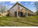 Tan two-story townhome with screened porch and grassy backyard at 18924 Duquesne Dr, Tampa, FL 33647