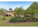 Landscaped backyard with mature trees and shrubs at 2028 Acadia Greens Dr, Sun City Center, FL 33573