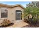 Front entrance with screen door, landscaping, and a small American flag at 2028 Acadia Greens Dr, Sun City Center, FL 33573