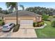 Tan house with two-car garage and landscaping at 2028 Acadia Greens Dr, Sun City Center, FL 33573
