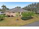 Rear view of tan house with lush landscaping at 2028 Acadia Greens Dr, Sun City Center, FL 33573