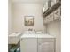 Laundry room with washer, dryer, and extra storage shelving at 2028 Acadia Greens Dr, Sun City Center, FL 33573