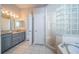 Bathroom with a large vanity, tile flooring and a shower with glass block at 2930 Swan Cir, Dunedin, FL 34698