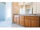Well-lit bathroom featuring a double vanity, wood cabinets, and a tiled floor at 2930 Swan Cir, Dunedin, FL 34698