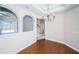 Open dining area with hardwood floors, decorative arches, and view to the outside, and staircase at 2930 Swan Cir, Dunedin, FL 34698