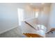 Bright hallway with hardwood stairs, carpet and white walls leading to the front door at 2930 Swan Cir, Dunedin, FL 34698