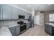 Charming kitchen features stainless steel appliances, light gray cabinets, and elegant granite countertops at 2930 Swan Cir, Dunedin, FL 34698