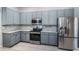 Well-equipped kitchen with stainless steel appliances, sleek gray cabinetry, and stunning granite countertops at 2930 Swan Cir, Dunedin, FL 34698