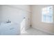 Functional laundry room featuring a utility sink, tiled floors, and natural light at 2930 Swan Cir, Dunedin, FL 34698