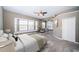 Staged main bedroom features large windows, plush carpet, and a ceiling fan at 2930 Swan Cir, Dunedin, FL 34698