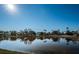 A tranquil pond reflects the blue sky and surrounding trees on a sunny day at 2930 Swan Cir, Dunedin, FL 34698