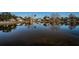 Still pond reflecting homes, trees, and blue skies creating peaceful community scene at 2930 Swan Cir, Dunedin, FL 34698