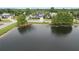 View of home from across the pond with manicured lawns and mature trees at 2930 Swan Cir, Dunedin, FL 34698
