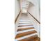 Staircase featuring wood stairs with white risers and wooden handrail at 2930 Swan Cir, Dunedin, FL 34698