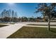 Neighborhood street view of sidewalk, manicured lawn, serene pond and well-kept homes at 2930 Swan Cir, Dunedin, FL 34698